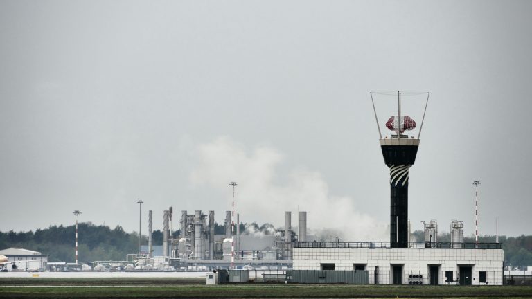 Control tower with industrial buildings in Lombardia, Italy, showcasing modern infrastructure.