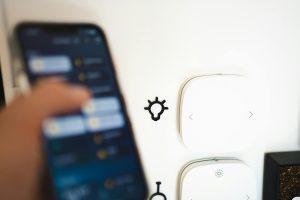 Blurry smartphone controlling smart home tech on a wall.