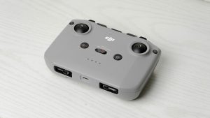 Grey DJI drone remote controller placed on a light textured table.