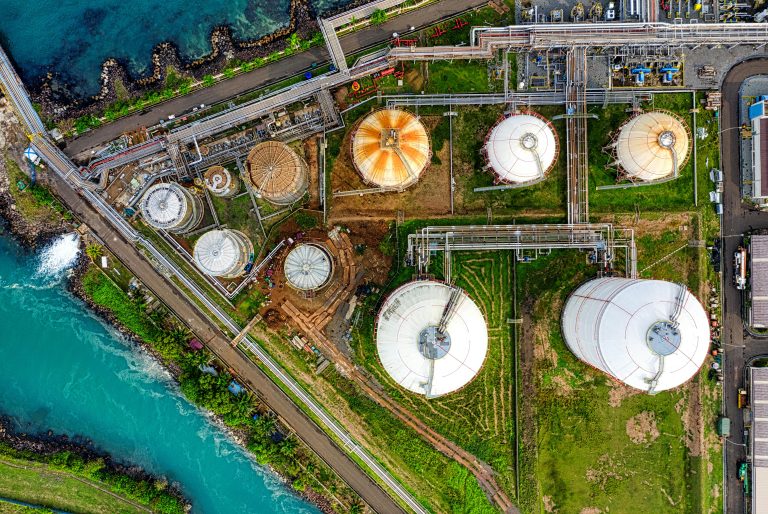 Aerial view of an industrial complex near a river in Banten, Indonesia, showcasing storage tanks.