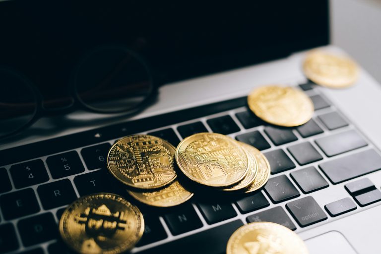 Close-up of gold bitcoins on a laptop keyboard symbolizing digital currency and technology.